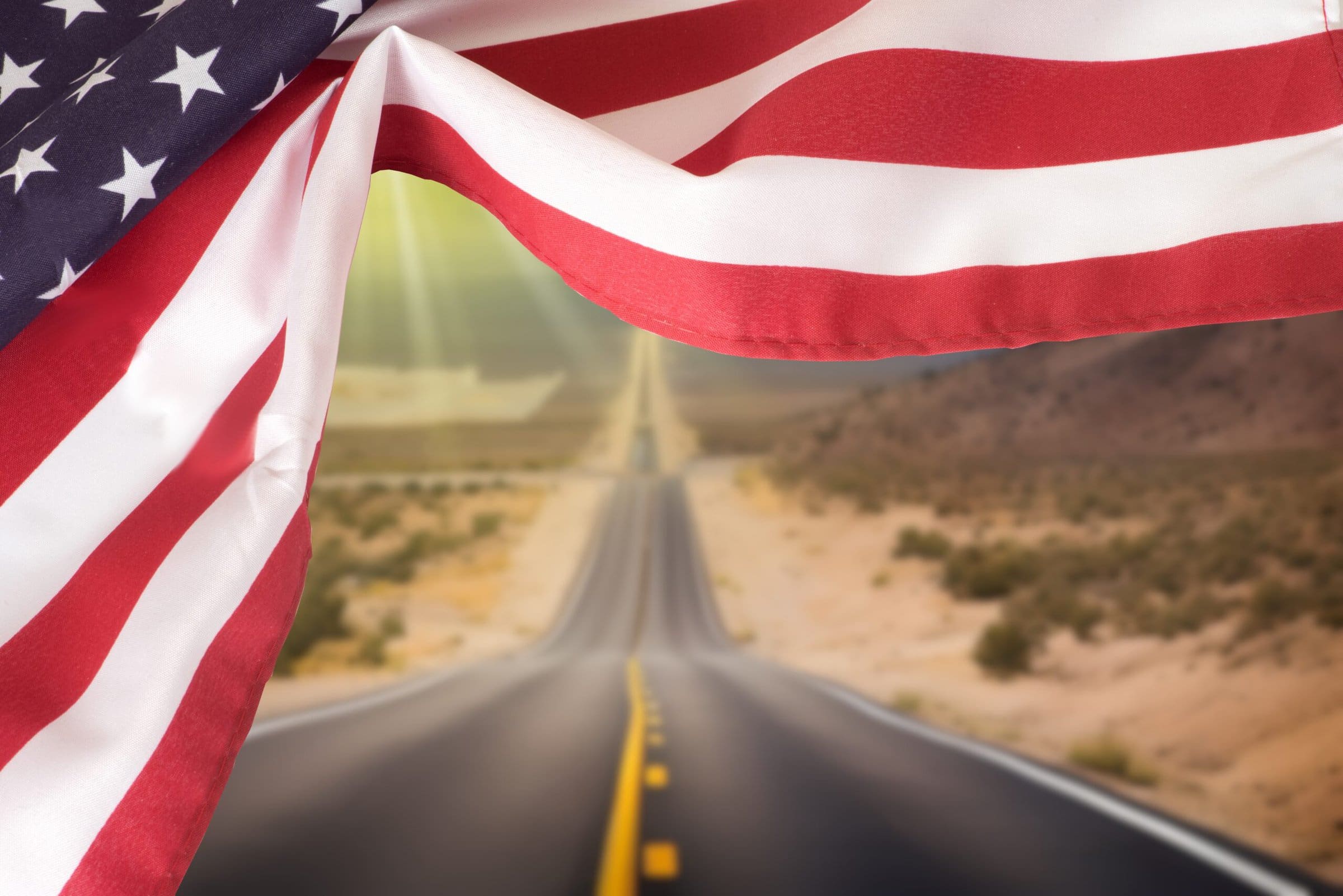 United,States,Flag,And,Road,Through,The,American,Desert